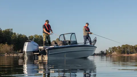 Twee mannen vissen op een boot op een meer. 