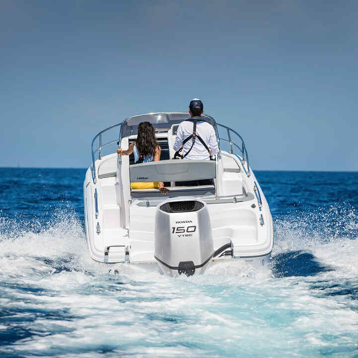 Koppel op een boot met een Honda BF150 motor op de oceaan.