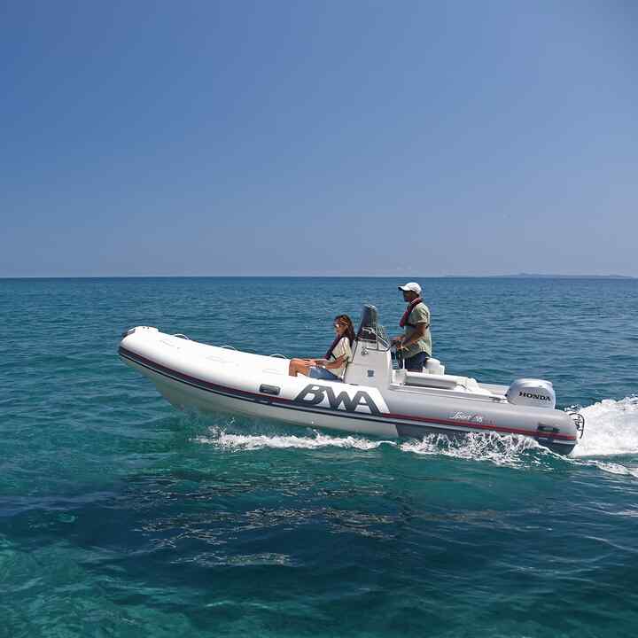 Koppel op een opzij gerichte Honwave met BF-motor aan de kust. 