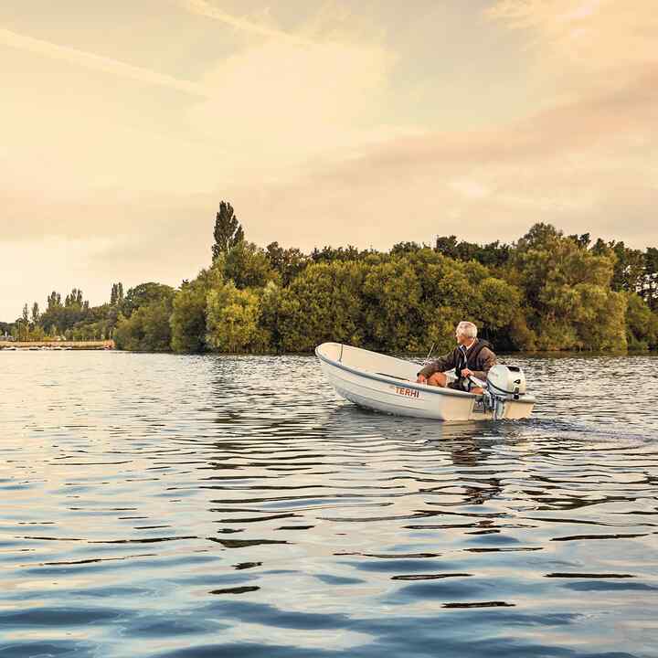 Man op een boot met Honda-motor op een locatie bij een meer. 