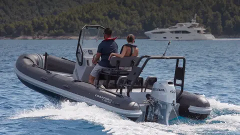 Koppel op een naar achteren gerichte Highfield-boot met BF50-motor in de oceaan.