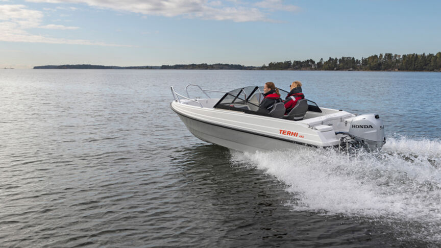 Man op een boot met een B40-motor in een kustgebied. 