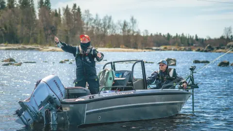 Twee mannen op een boot die vissen met een Honda BF60-motor op een meer. 