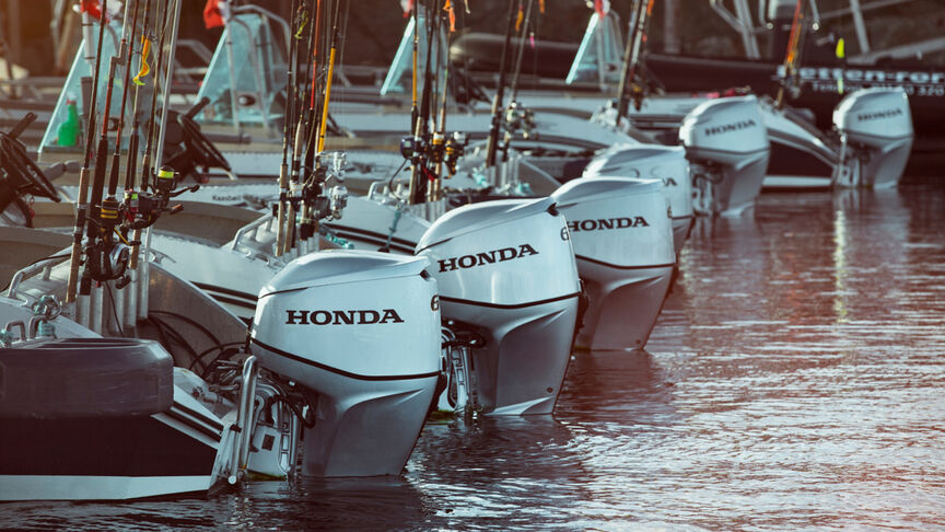 Een reeks Honda BF60-motoren achter op boten in het water. 