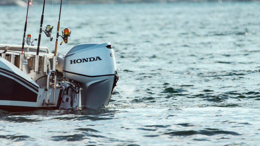 Een reeks Honda BF60-motoren achter op boten in het water. 