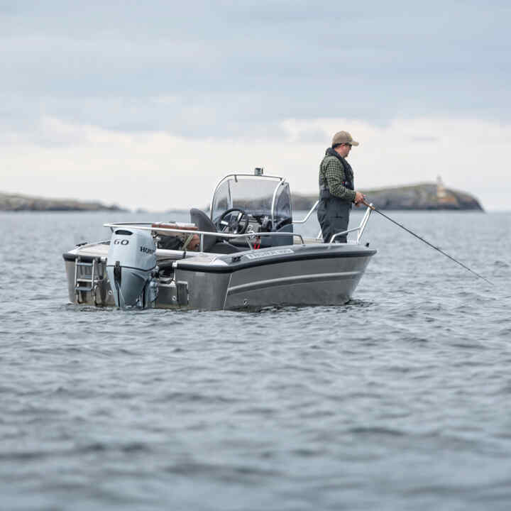 Een man op een boot met een Honda BF60-motor op de oceaan. 