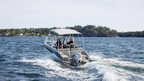 Modellen die een boot besturen met de BF80-100-motor op zee.