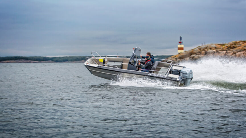 Model dat een boot bestuurt op zee met de BF80-100-motor.