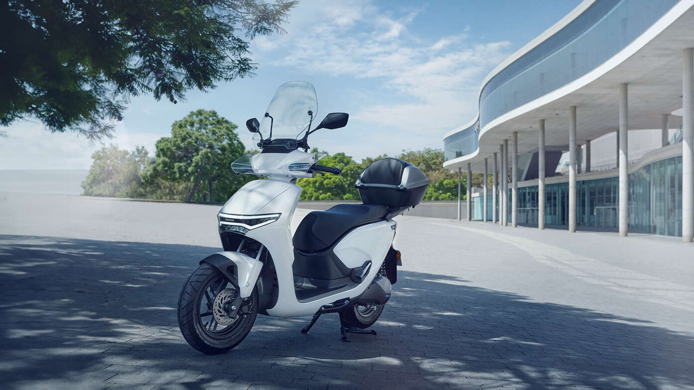 Honda CUV e motorfiets demonstreert het scherm geparkeerd in stadsomgeving.